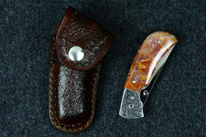 "Bellatrix" custom folding knife with random tooling pattern brown pocket sheath with brown heavy stitching and marine grade dot snaps